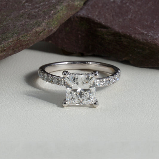 Diamond ring with a square-cut gemstone on a neutral background